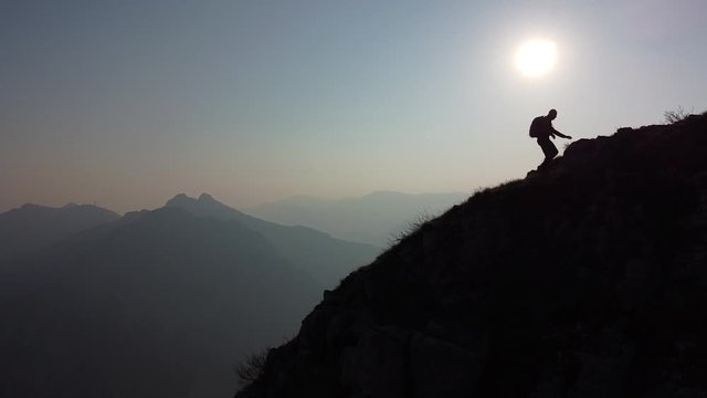 Hiker walking on mountain ridge, European Alps, Lecco, Italy