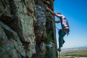 Obraz premium Rock climber climbing up a cliff