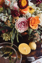 Flower decoration with a silver plate and fruits on the wooden table