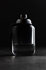 Bottle of men's perfume  on a black stone background. Fashion concept.