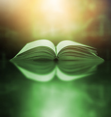 The blurred book that is bewitched with magic, the magic light in the dark, with the bright light shining down as the power to search for knowledge. For research and use as a blurred background