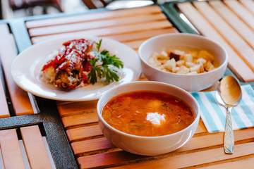 Red Ukrainian borsch with sour cream and other dishes in canteen