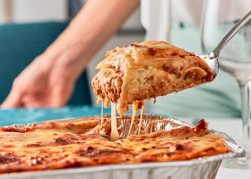 woman serving portion of lasagna food