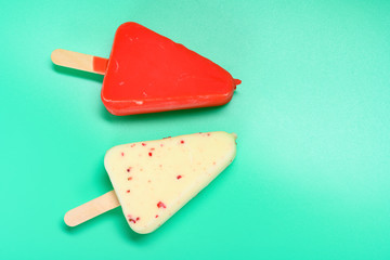 red and white chocolate outers popsicles on green background with copy space