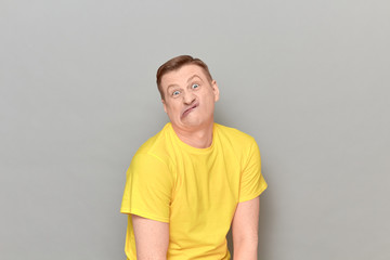 Obraz premium Portrait of funny puzzled mature man making goofy crazy face