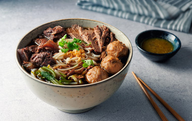 Braised Beef and Meat Ball Noodles Soup on concrete table