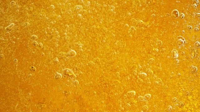 Super Slow Motion Detail Shot of Rippling Beer Bubbles in Glass at 1000fps.