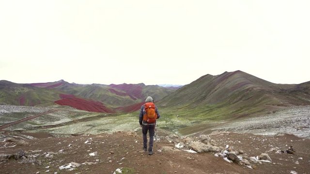 Young man hiking towards Red Valley in Peru, Andes Mountain Range, slow motion