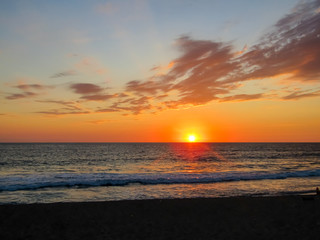 Sunset at sea in a stunning sunset with dramatic sky formed by the reflection of the sun in the clouds, in Mazatlan Mexico
