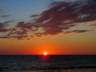 Sunset at sea in a stunning sunset with dramatic sky formed by the reflection of the sun in the clouds, in Mazatlan Mexico