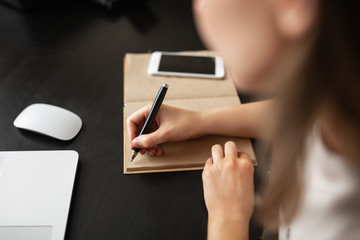 a girl does work from home during isolation, writes notes in a notebook during quarantine and pandemic.