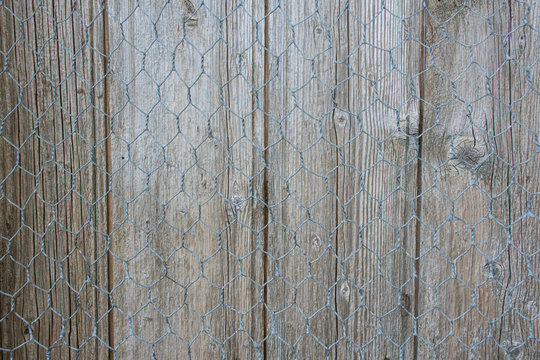 Textura de madera ajada y gris con alambre de metal tejido.