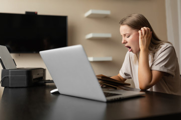 pretty girl doing work from home cute yawns tired during quarantine. Home workplace