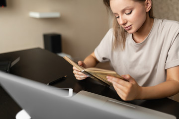 beautiful girl freelancer does work from home checks notes in a notebook during quarantine. Home...