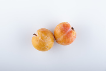 Juicy yellow plums with leaves, isolated on white background.