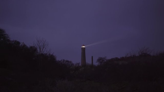 Lighthouse of the frisian north sea island Borkum sending beams of light illuminating the dark night sky