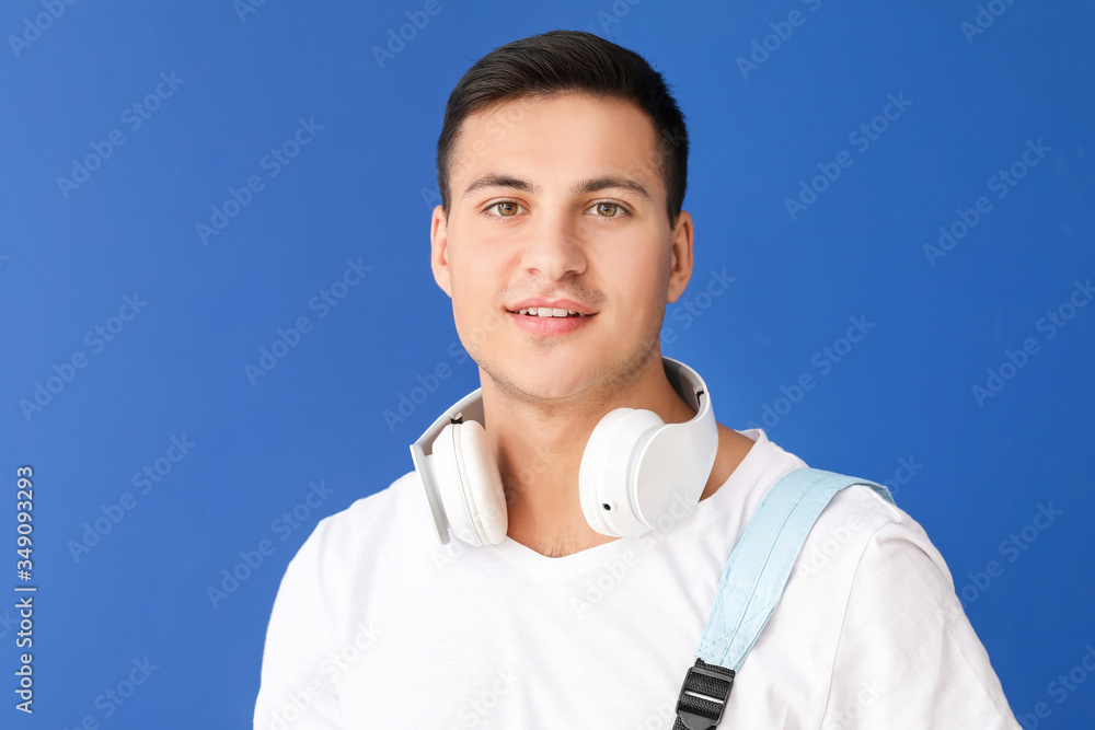 Wall mural Portrait of male student on color background