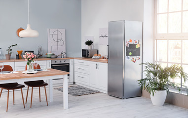 Interior of modern kitchen with refrigerator