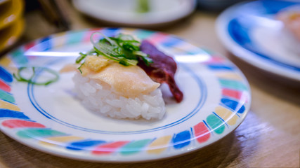 Sushi in a Japan restaurant. Traditional Kaitenzushi Japanese food. Sushi train.