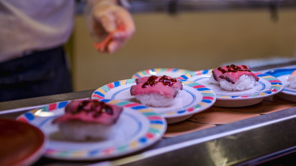 Sushi on conveyor belt in Japan restaurant. Sushi train is a Japanese fast food