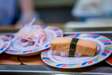 Sushi on conveyor belt in Japan restaurant. Sushi train is a Japanese fast food
