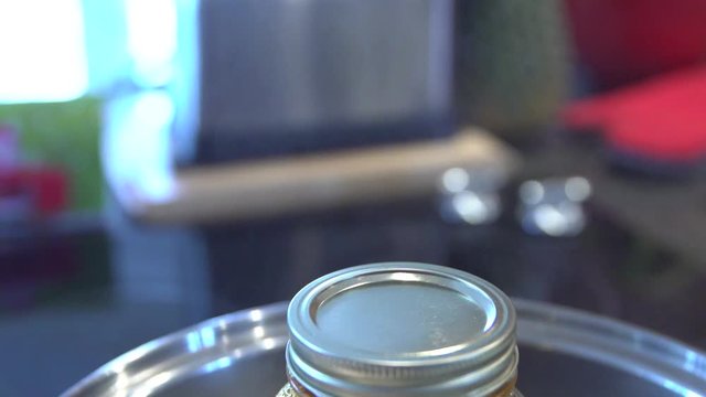 Extract Of Medical Cannabis In A Jar Heated On Boiling Water - tilt down close up