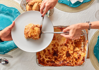woman serving portion of lasagna food zenith