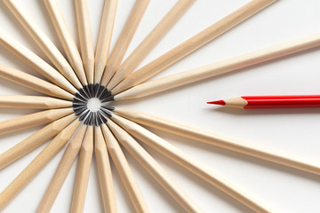 Top view of a red pencil tends to fall into circle of gray pencils
