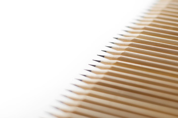 Row of sharpened stationery pencils lie in row with each