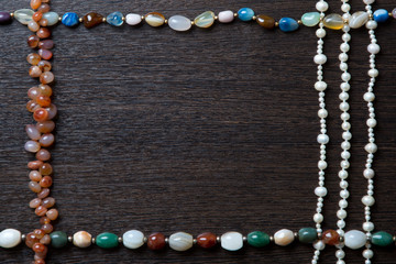 necklaces are laid out on a wooden table in the form of a frame