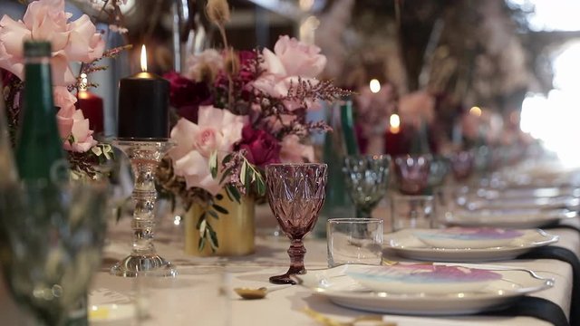 Panning showing the glassware and decorations used on a table at a wedding reception