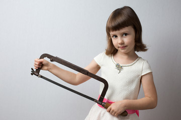 Girl holding a hacksaw in her hands