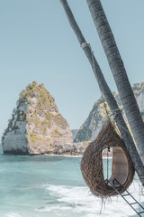 Trendy Balinese bird-nest style seating with view of Diamond Beach. Nusa Penida, Bali, Indonesia.