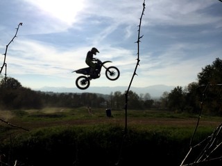 Motocross Rider In Mid-air Over Field Against Sky
