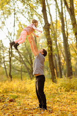 Father and daughter have fun together. Dad throws his daughter up in the sky.