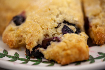 Blueberry scones closeup cut in triangles on a round plate.