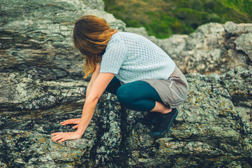 Young woman squatting on rocks in nature