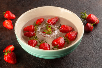 Washing process of fresh,ripe Strawberries in water in ceramic plate.Close up.Splash of water.