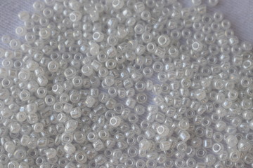 White beads scattered on a white background.