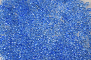 Blue beads scattered on a white background.