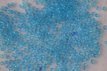 Blue beads scattered on a white background.
