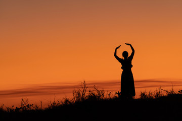 Dancer's silhouette against the golden sky. Mindil Beach, Darwin, NT, Australia.