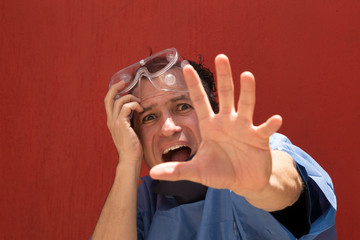 White man in surgical clothing, in a scare attitude, terror, no one comes near, do not touch me,...