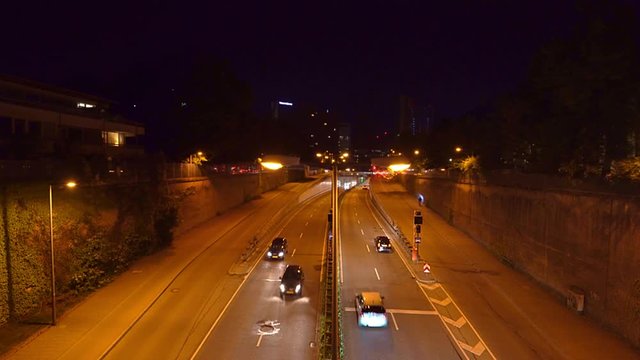 Night scenery of driving cars in Munich at normal speed. Stop and go at the Effnerplatz, wide view from a bridge, central place in the bavarian capital.