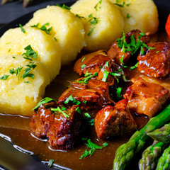 dumplings with beef goulash and green asparagus