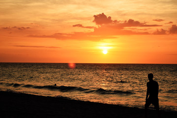 beautiful sunset on the ocean and people silhouettes