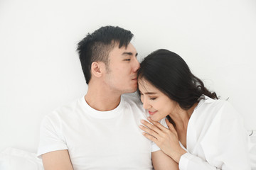 Obraz na płótnie Canvas asian couple kiss in the bed