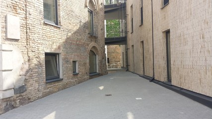 Narrow street in the old town between new and old buildings
