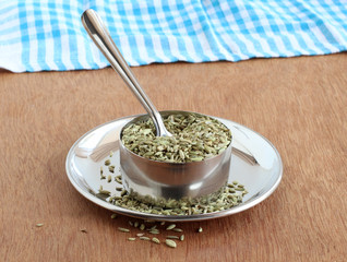 Fennel seeds, or soumph, a healthy food, are said to aid digestion and work as a mouth freshener, in a steel bowl with a spoon on a steel plate.