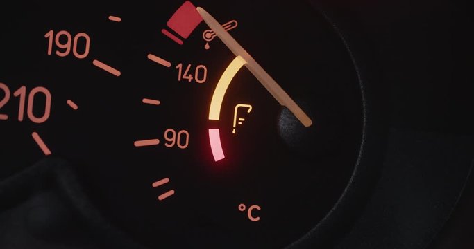 Car dashboard closeup - engine oil temperature gauge performing an oil level test.